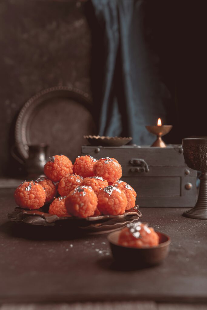 orange motichoor laddoo topped with pistachio and silver foil