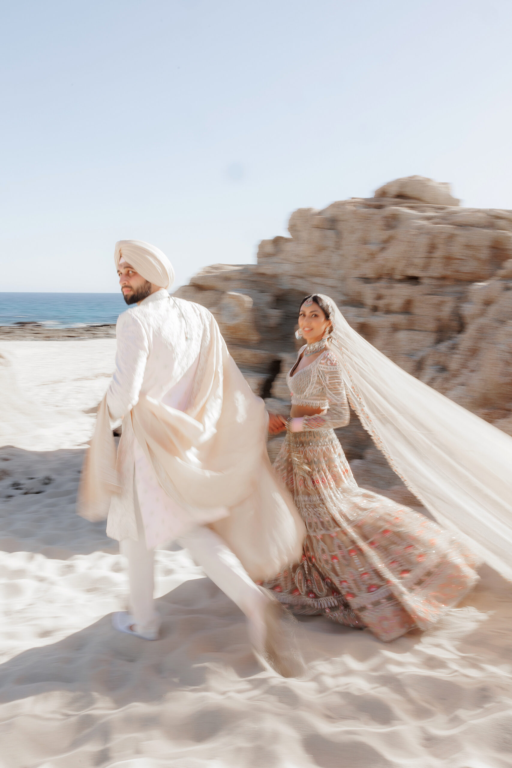 bride and groom wearing pastel Indian wedding attire