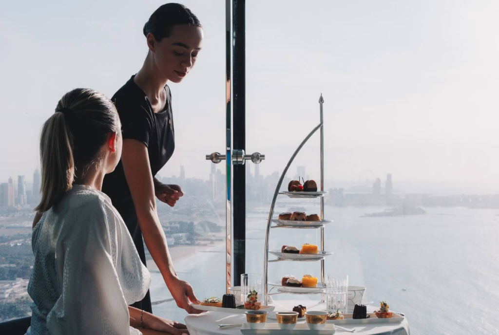 Girl serving tea and cake in Burj Al Arab 