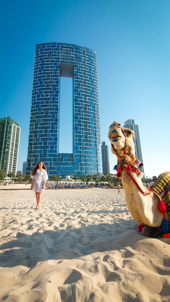 woman and camel on the beach in Dubai