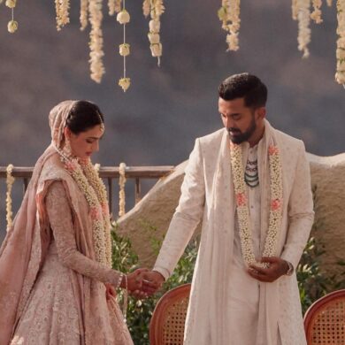 Indian bride and groom holding hands in Indian wedding outfits