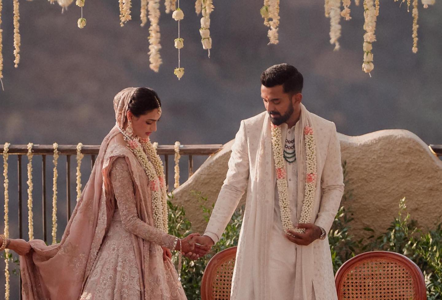 Indian bride and groom holding hands in Indian wedding outfits