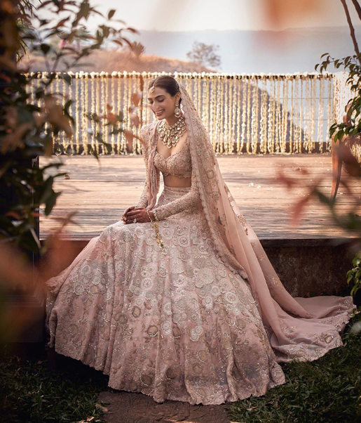 Indian bride in dust pink embroidered lehega with dupatta