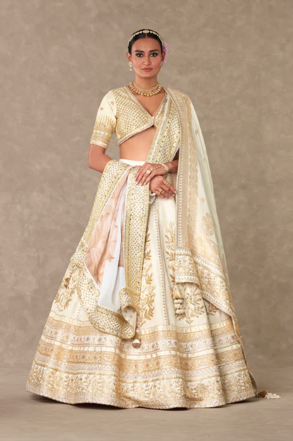 girl wearing white and gold ivory lehenga